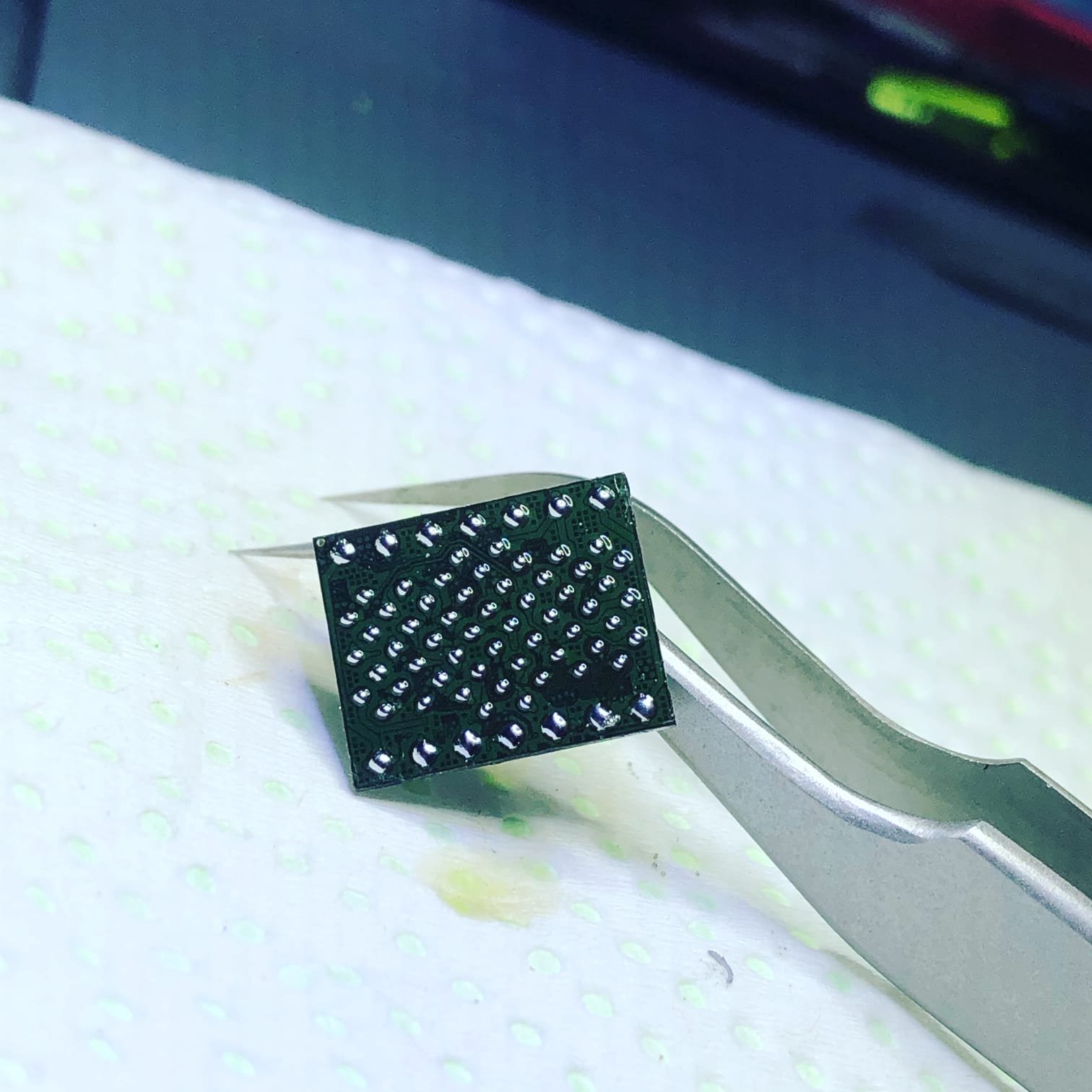 Componente BGA sostenido con pinza de precisión